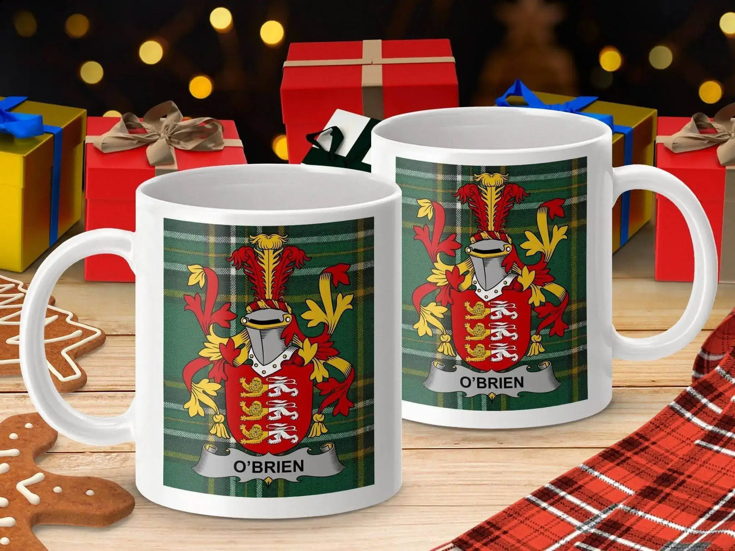 White mugs with O'Brien family crest on green tartan background and Christmas gifts in festive setting