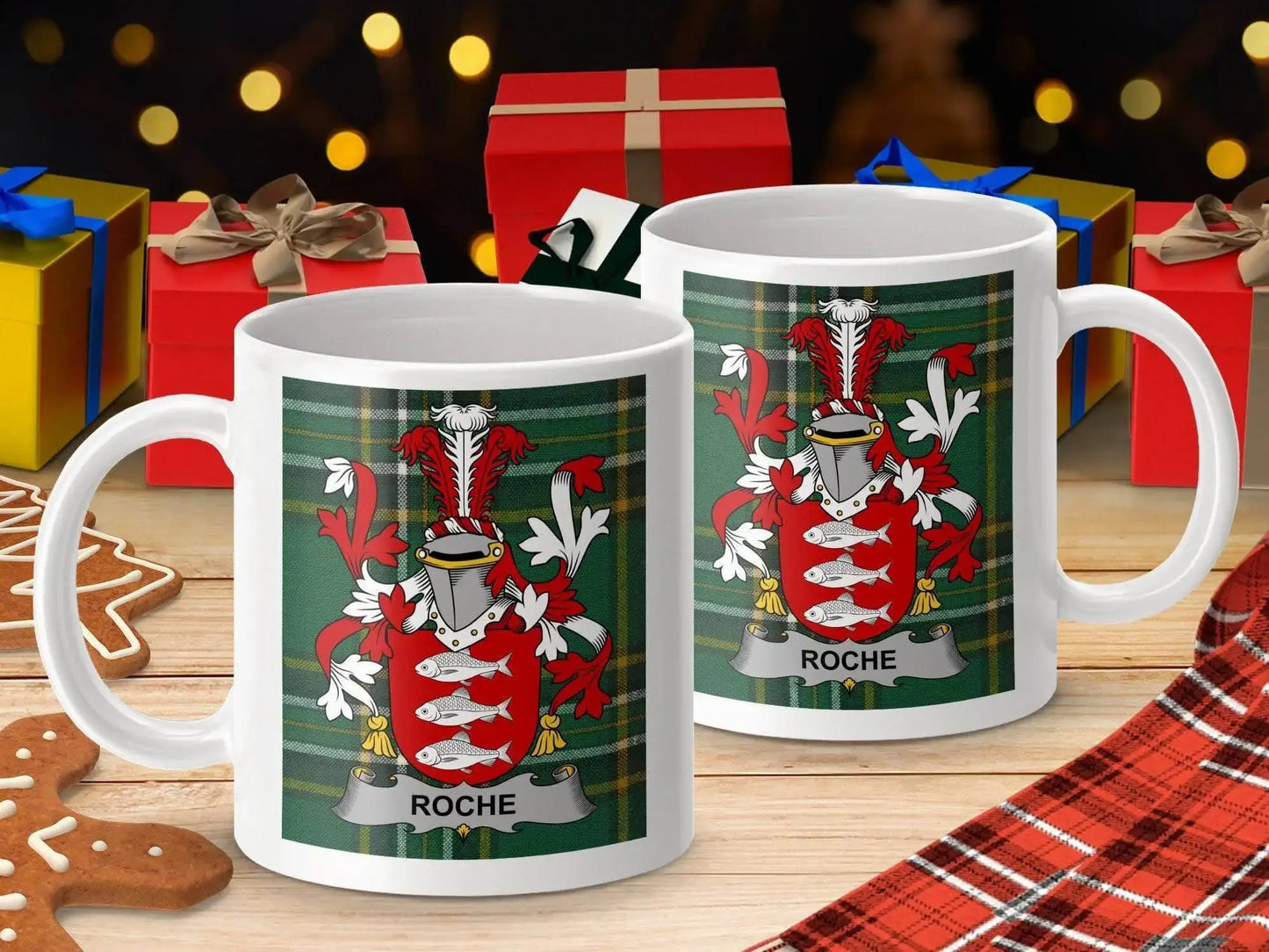 White mugs with Roche family crest on green tartan background, surrounded by Christmas gifts and gingerbread