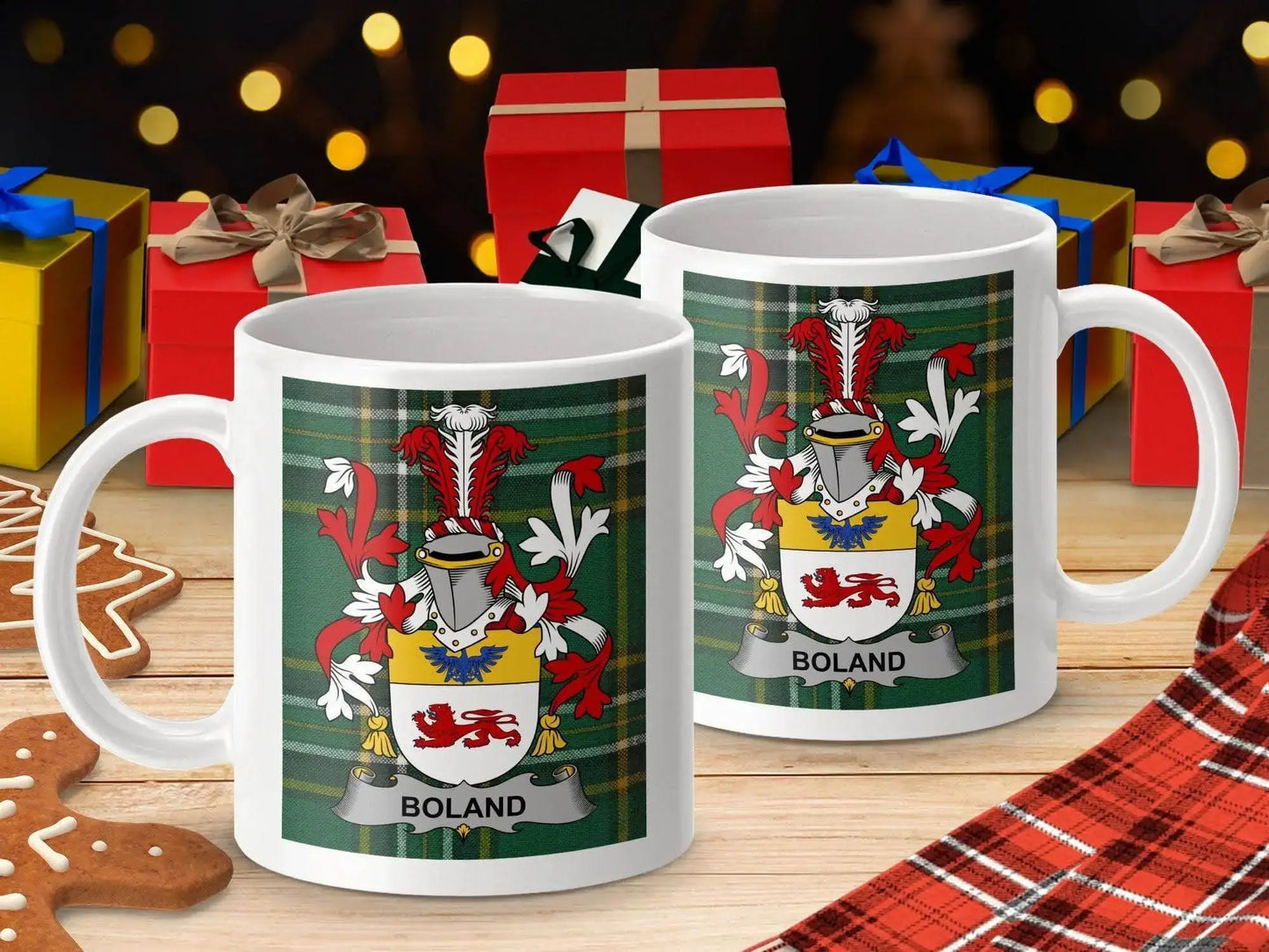 Two white mugs with Boland family crest on green tartan background, holiday gifts and gingerbread on wooden surface