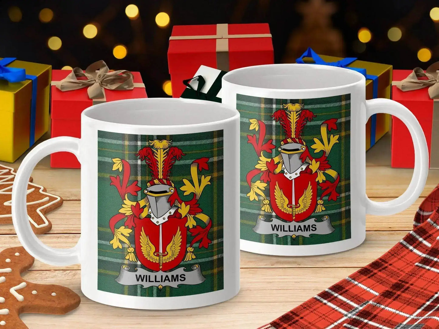 White mugs with Williams family crest on green tartan background amid holiday gifts and gingerbread cookies