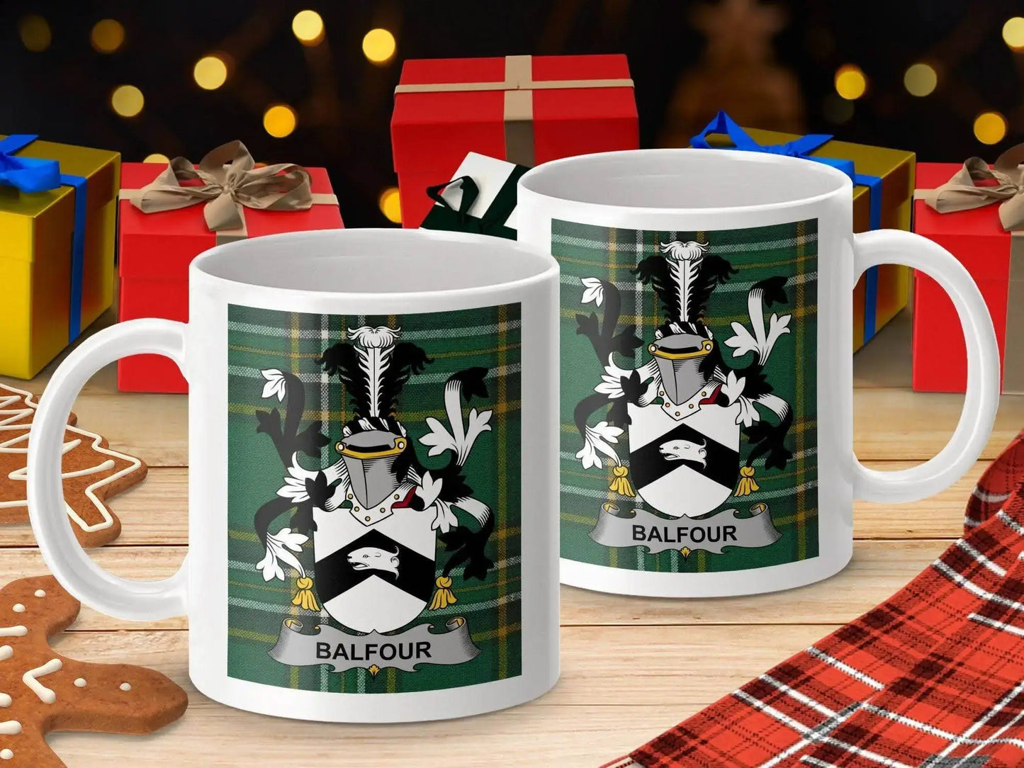 Two white mugs with Balfour family crest and green tartan background on wooden table with gifts and gingerbread cookies