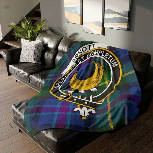 Scottish Arnot clan tartan fleece blanket draped on black leather sofa in modern living room