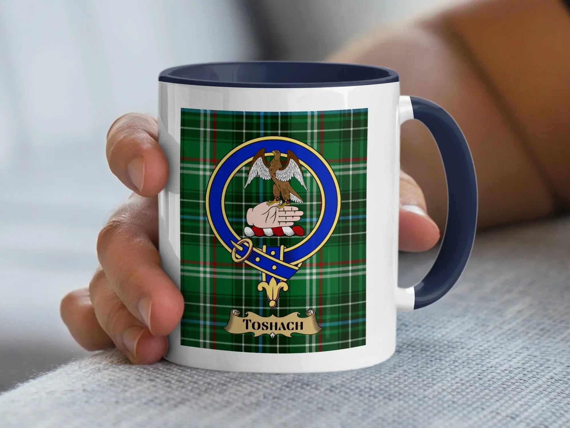 Toshach family crest mug with the crest set over a tartan background, a Scottish heritage gift for a Perthshire surname meaning chief