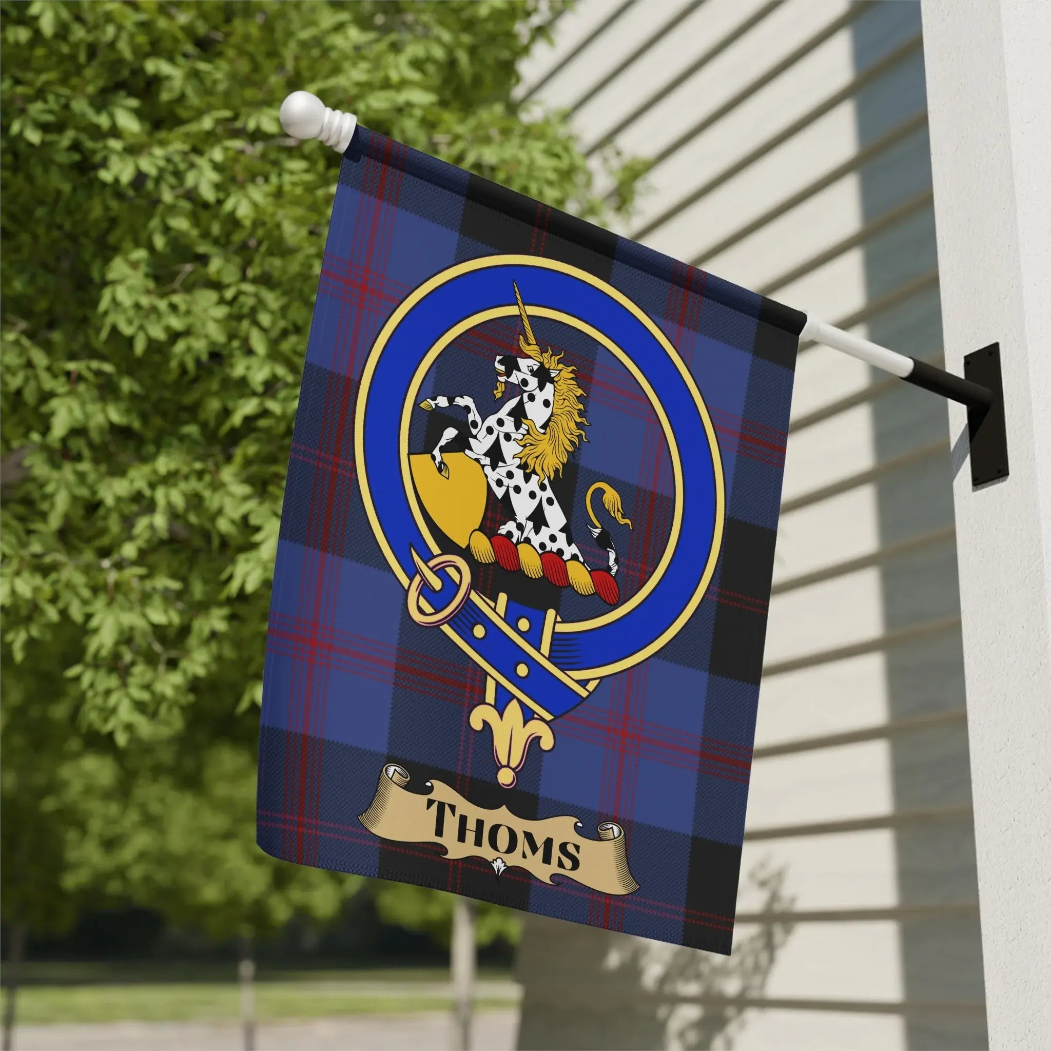 Thoms family crest garden flag on a woven tartan background, an Angus and Dundee surname banner for a porch