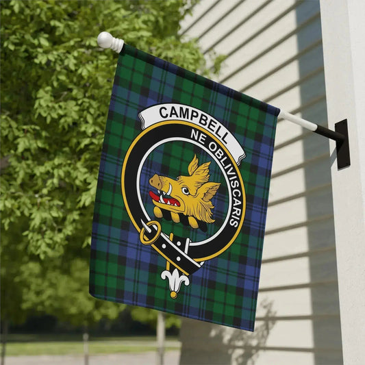 Green and blue tartan Campbell clan flag with a boar's head emblem and the motto Ne Obliviscaris hanging on a white exterior wall
