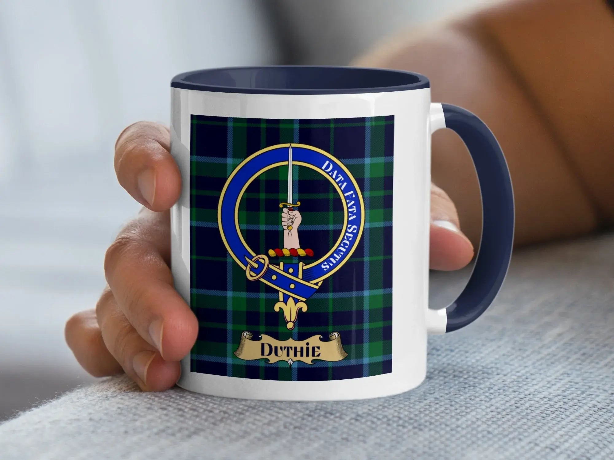 Duthie family crest mug on a tartan background, a Scottish heritage gift for the Aberdeenshire Duthie surname