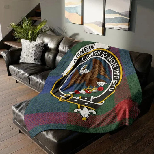 Agnew Clan Crest tartan throw blanket with eagle emblem draped over black leather sofa in modern living room