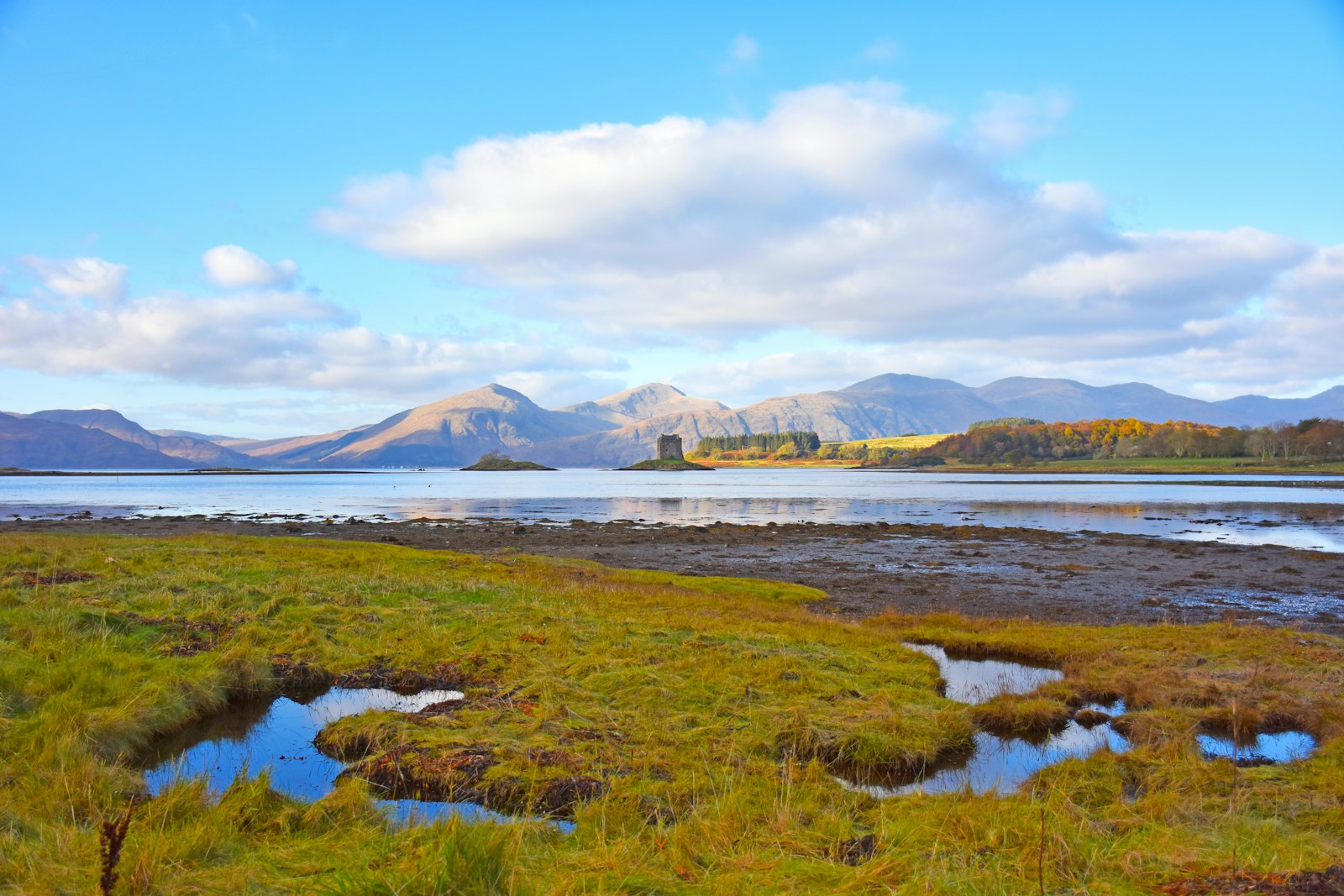 Castle Stalker four-storey tower house rising from a rocky tidal islet on Loch Laich Argyll at dusk, stronghold of Clan Stewart of Appin in the West Highlands of Scotland