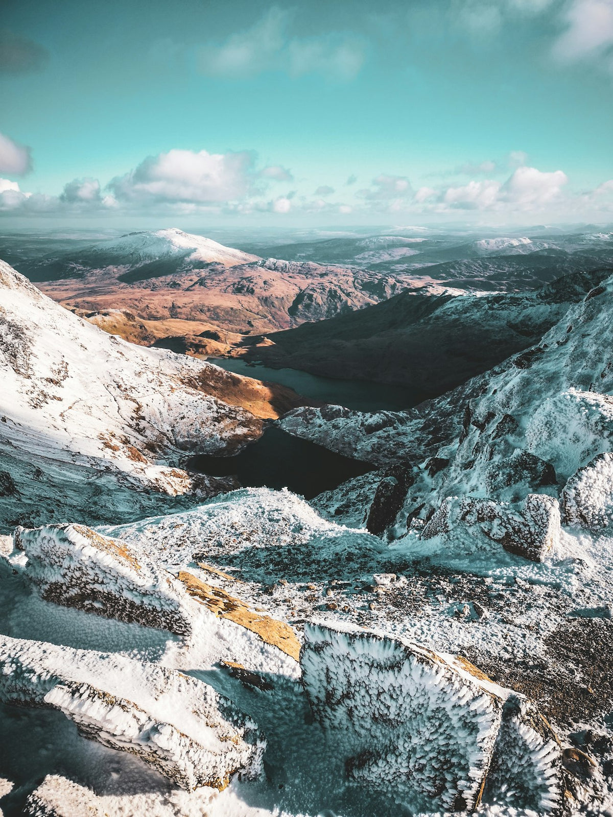 Snowdonia National Park Wales – snow-capped mountains under a winter blue sky, the heartland of North Welsh surname heritage