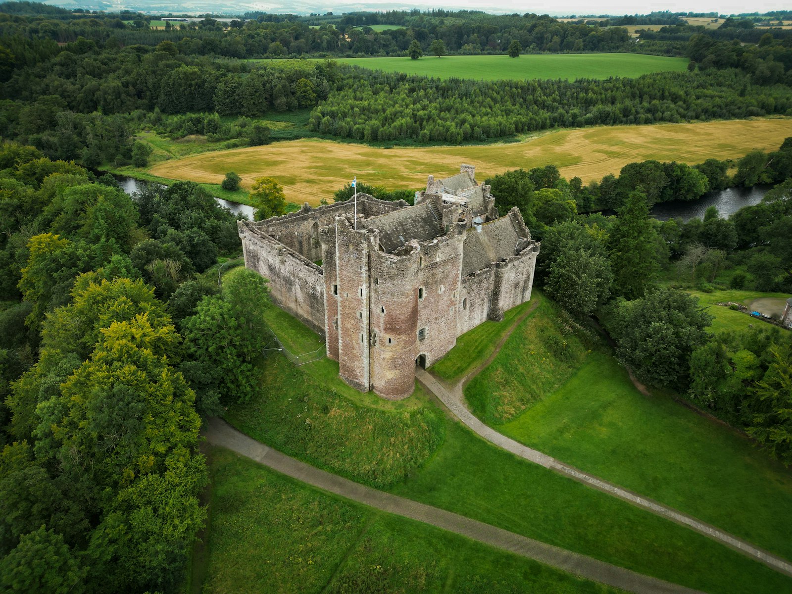 Aerial view of Doune Castle medieval fortress surrounded by trees above the River Teith in Stirlingshire Scotland, filming location for Outlander and Monty Python and the Holy Grail