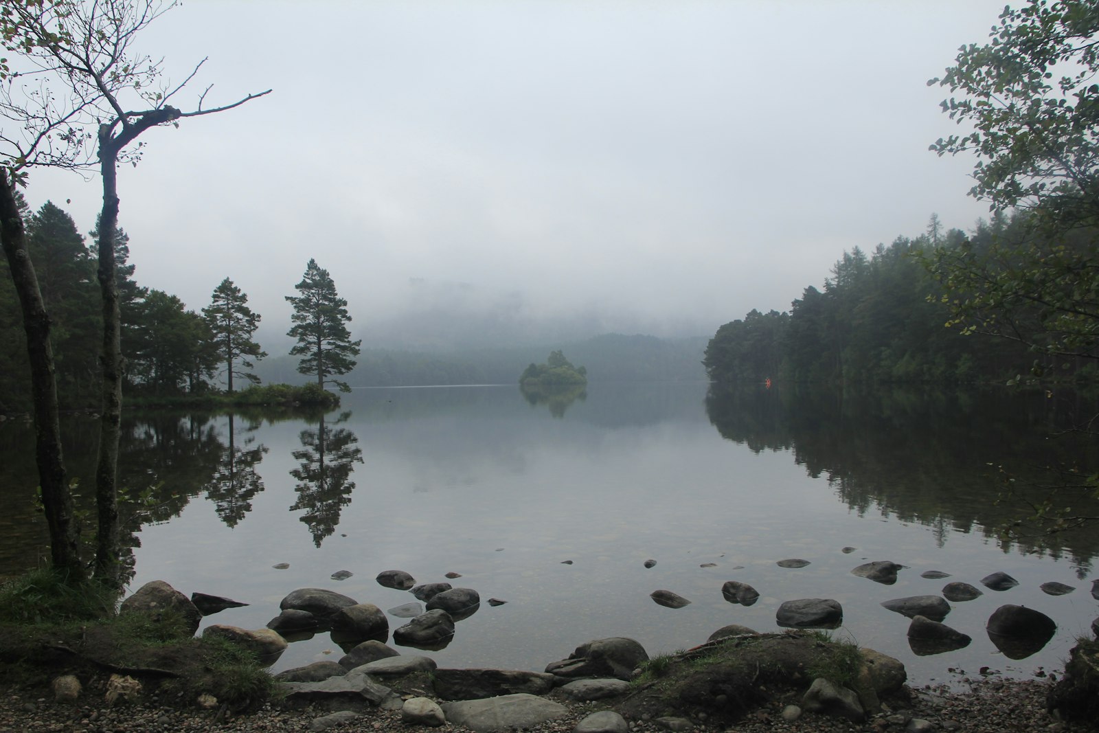 Scottish castle reflected in a still loch surrounded by trees — evoking the island setting of Threave Castle in the River Dee, stronghold of the Black Douglas earls of Galloway