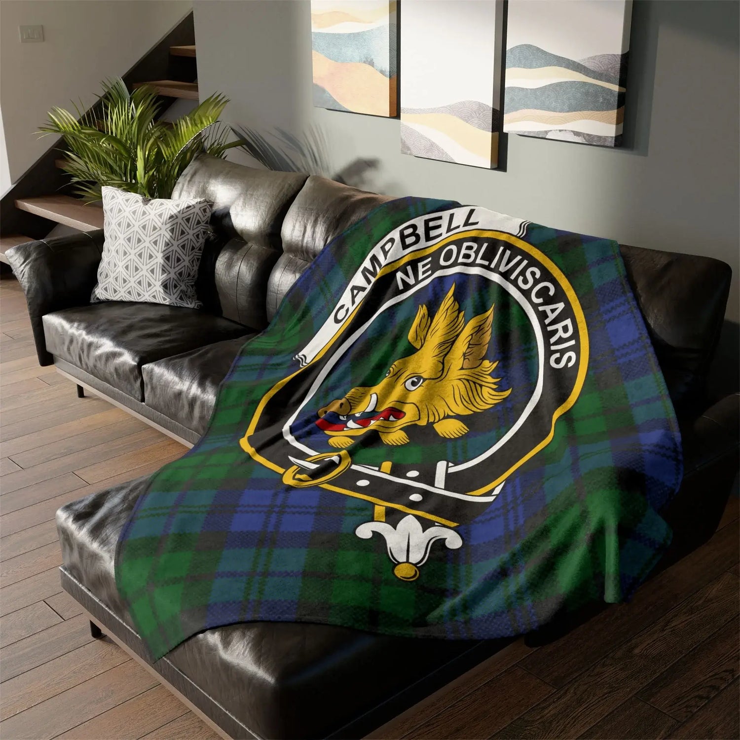 Campbell clan tartan fleece blanket with boar crest and motto on black leather sofa