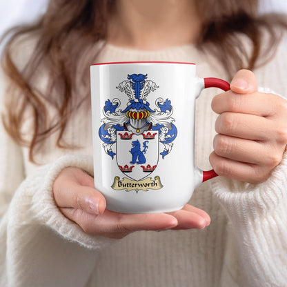 White mug with red handle and rim, displaying the Butterworth family crest.