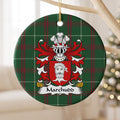 Marchudd ceramic ornament hanging from a pale wooden branch, showing a red shield with a white bearded head on Welsh national tartan.