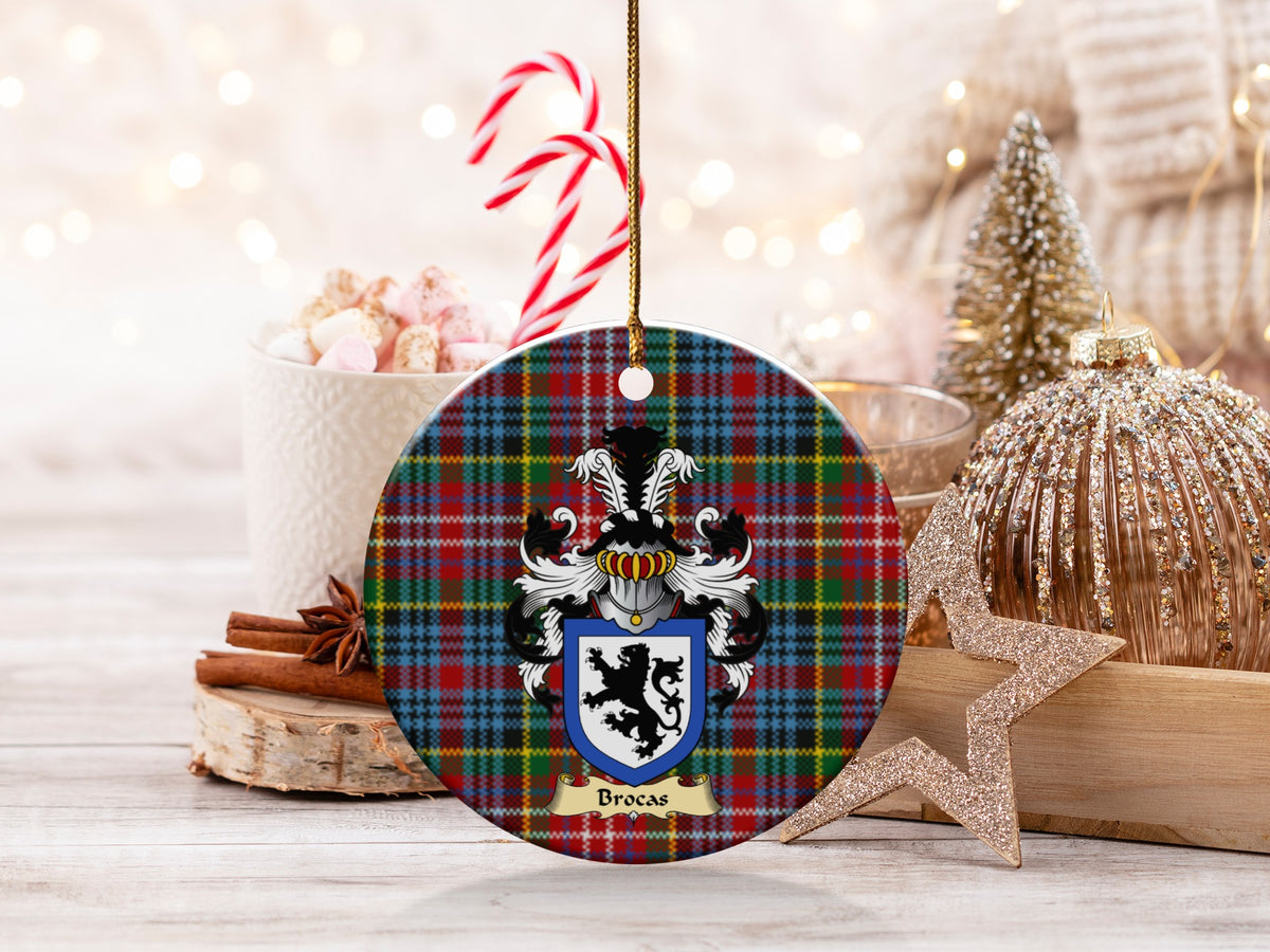 Brocas family emblem ceramic Christmas ornament with Caledonia tartan background in festive holiday décor