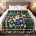 Somerville family crest woven blanket with plaid border on a bed.