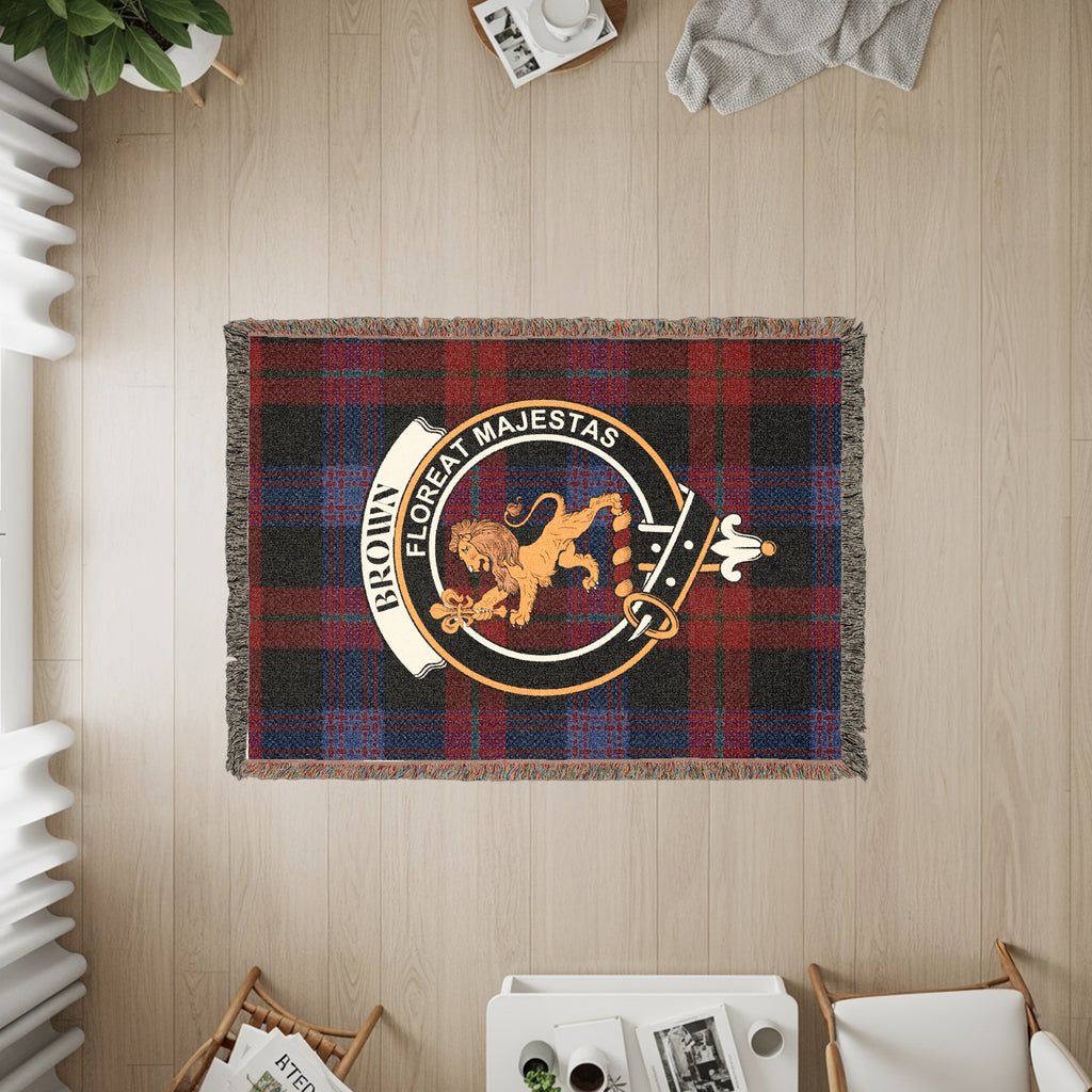 Brown clan crest with lion and motto "Floreat Majestas" on a red plaid blanket.