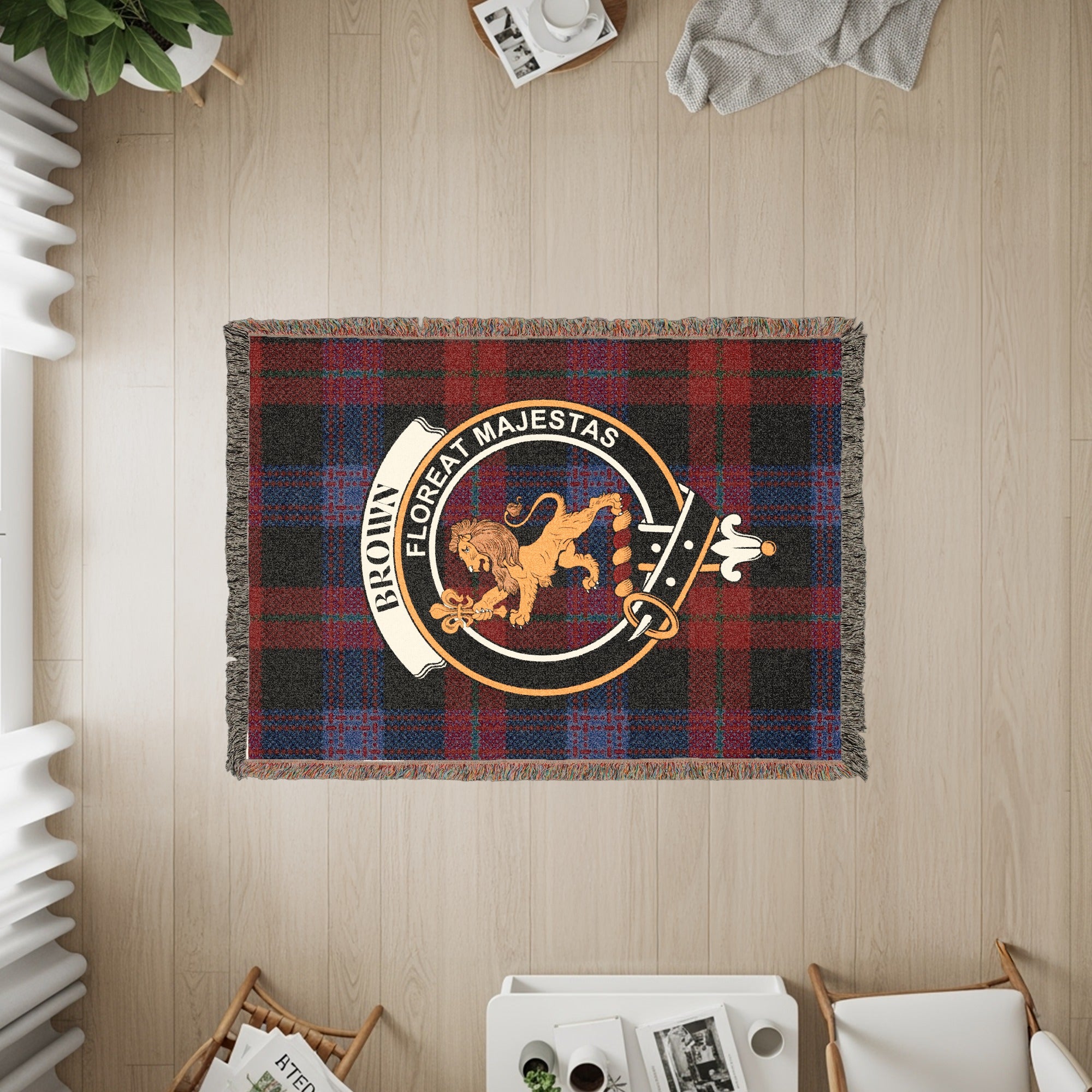 Brown clan crest with lion and motto "Floreat Majestas" on a red plaid blanket.