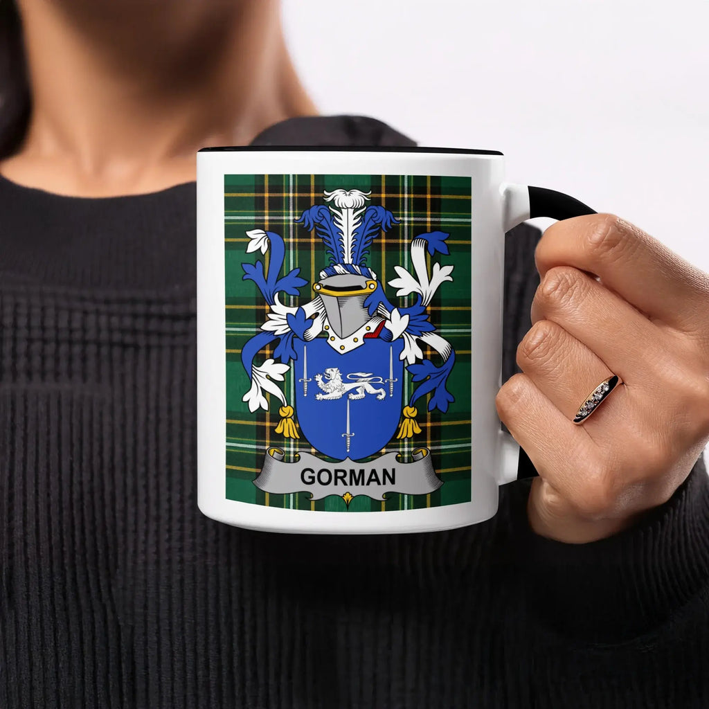 Black mug with a blue and white Gorman family crest on a green tartan background.