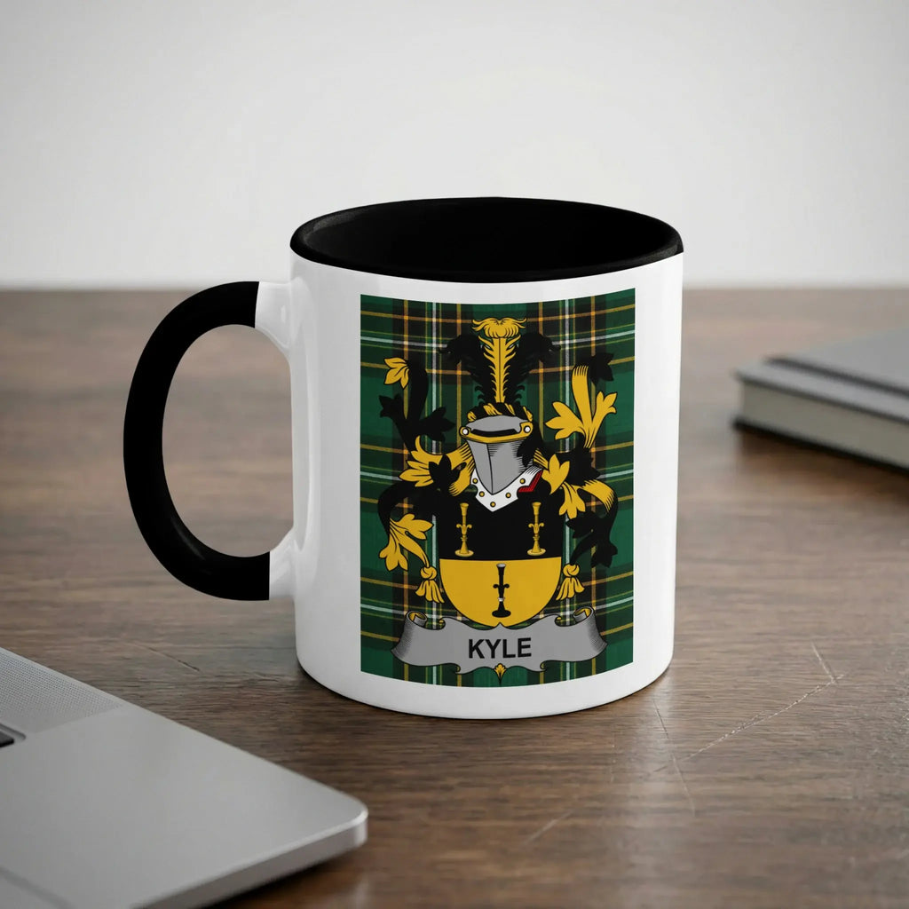 White mug with black handle displaying the Kyle family crest on a wooden desk.