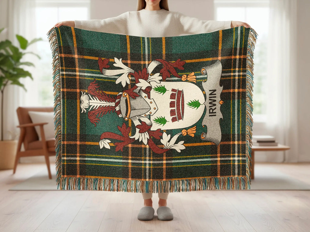 Tartan blanket with Irwin crest and fringed edges, held by a person.