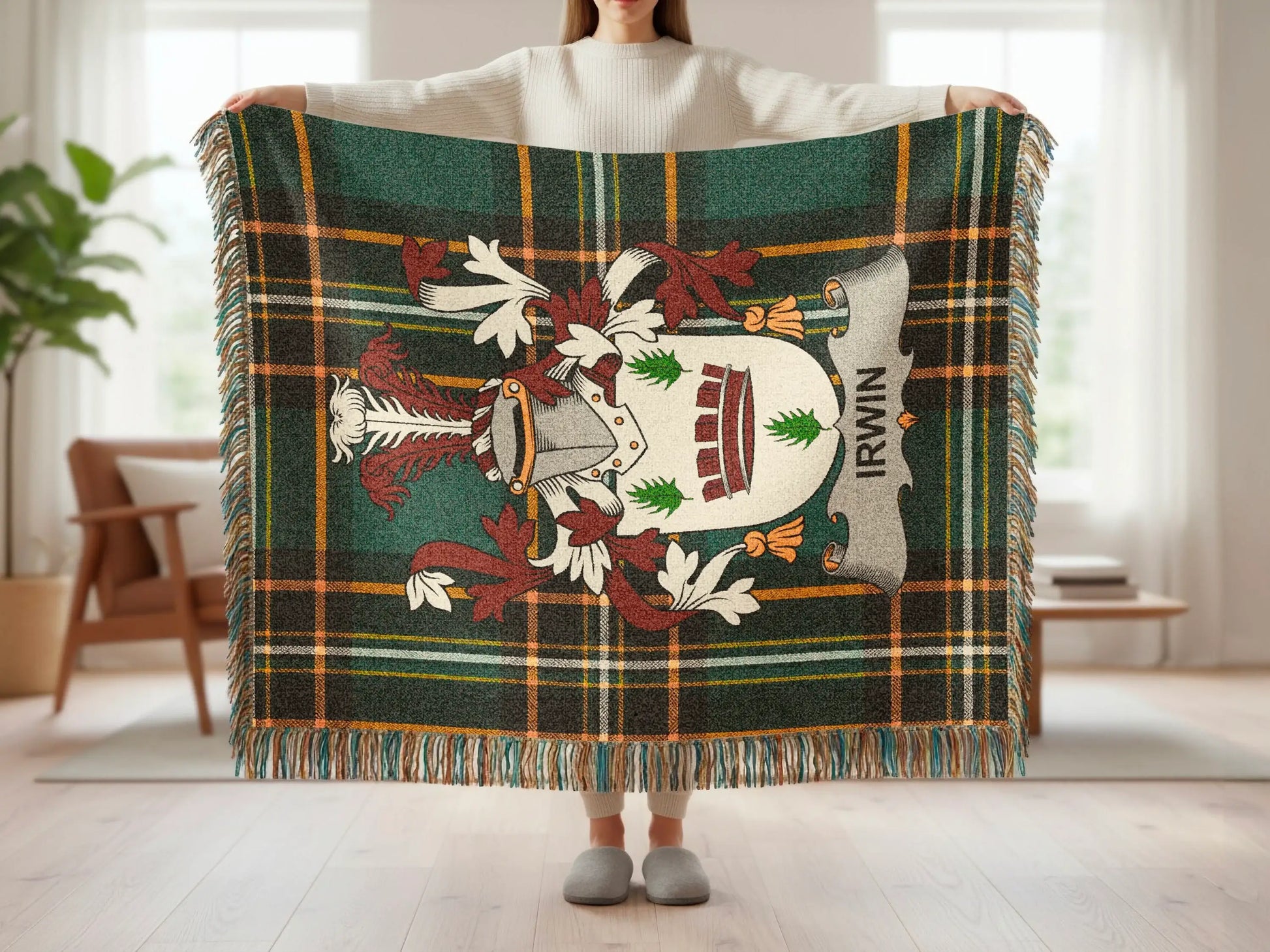Tartan blanket with Irwin crest and fringed edges, held by a person.