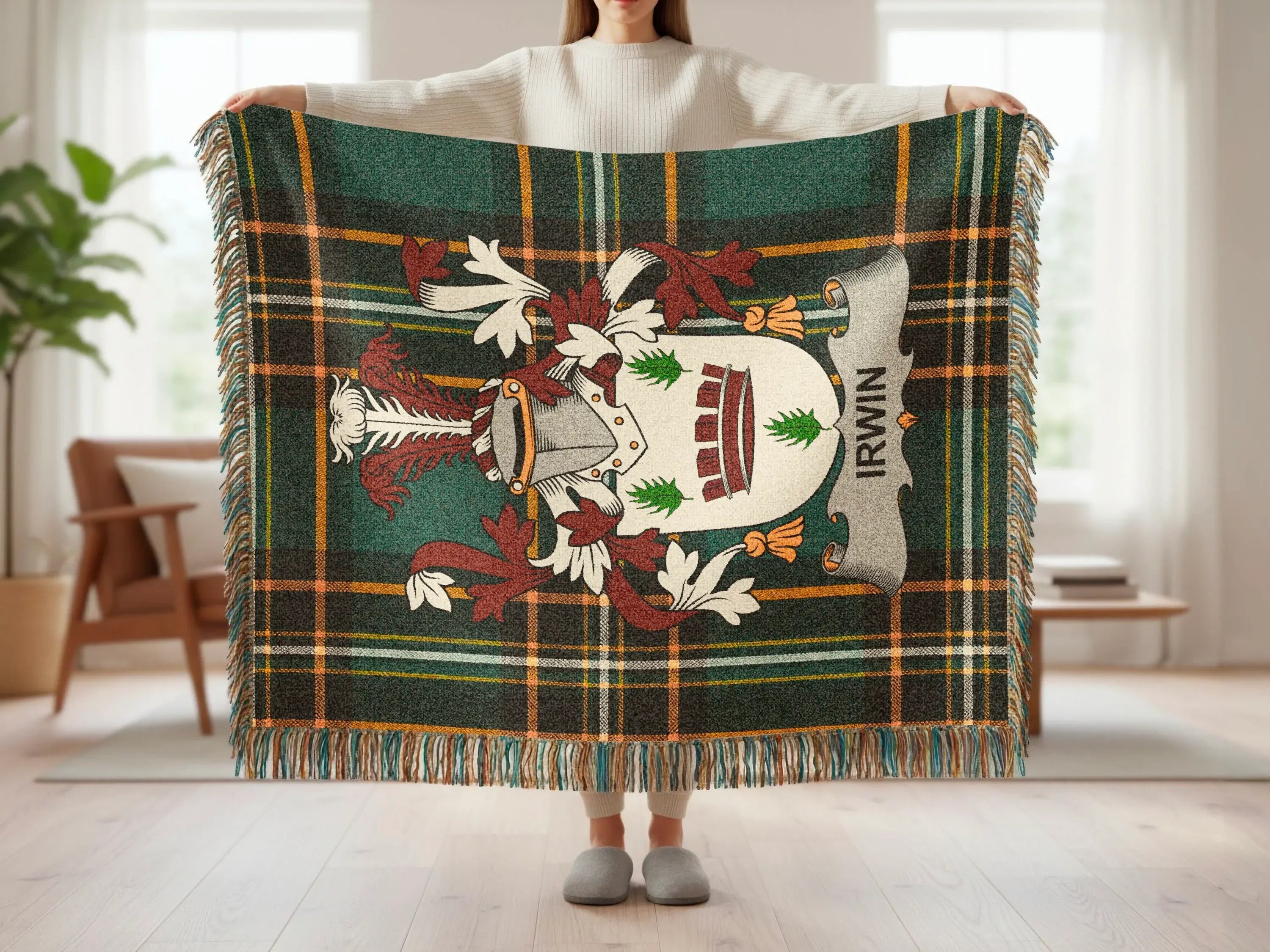 Tartan blanket with Irwin crest and fringed edges, held by a person.