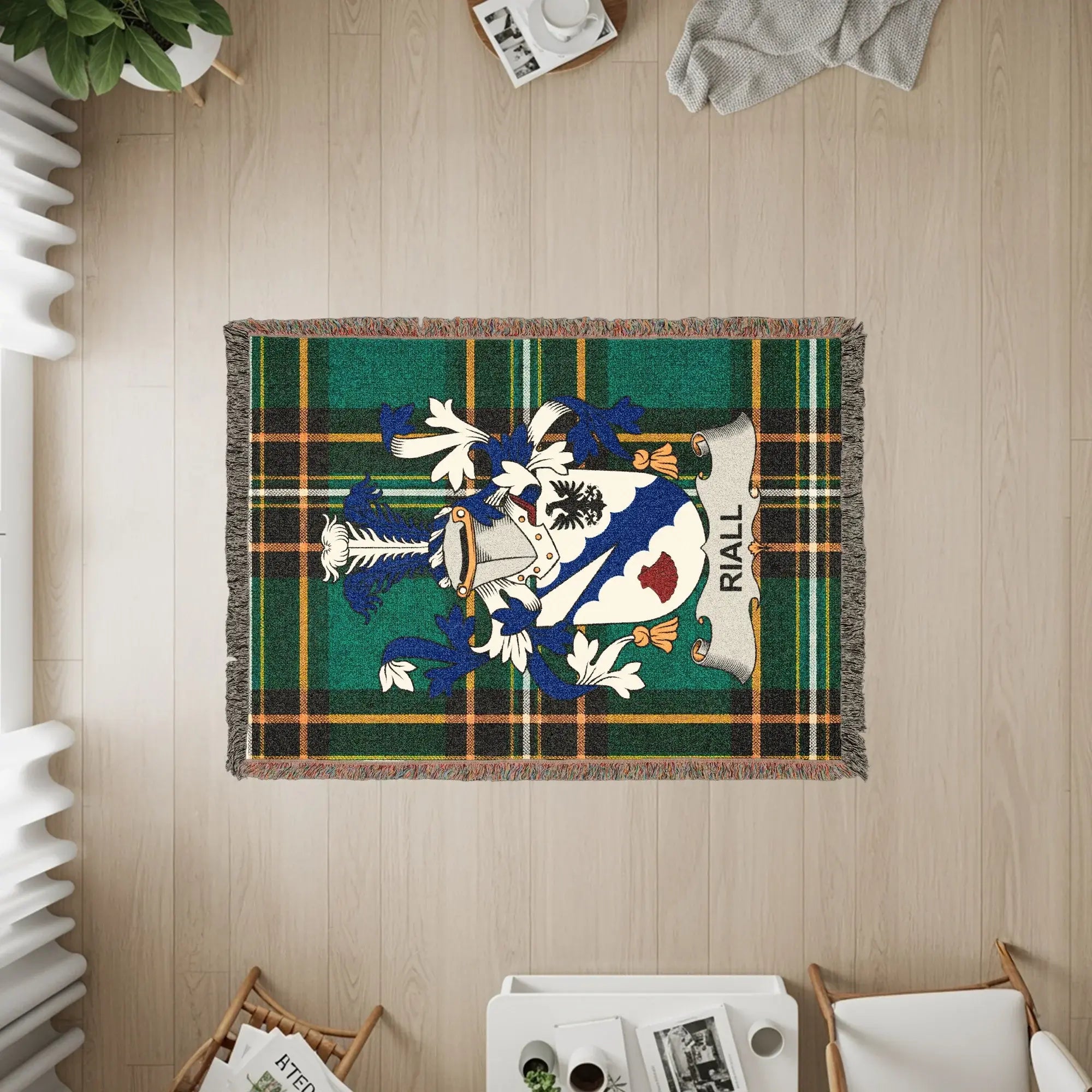 Rialla clan crest on a green tartan woven blanket with fringe.