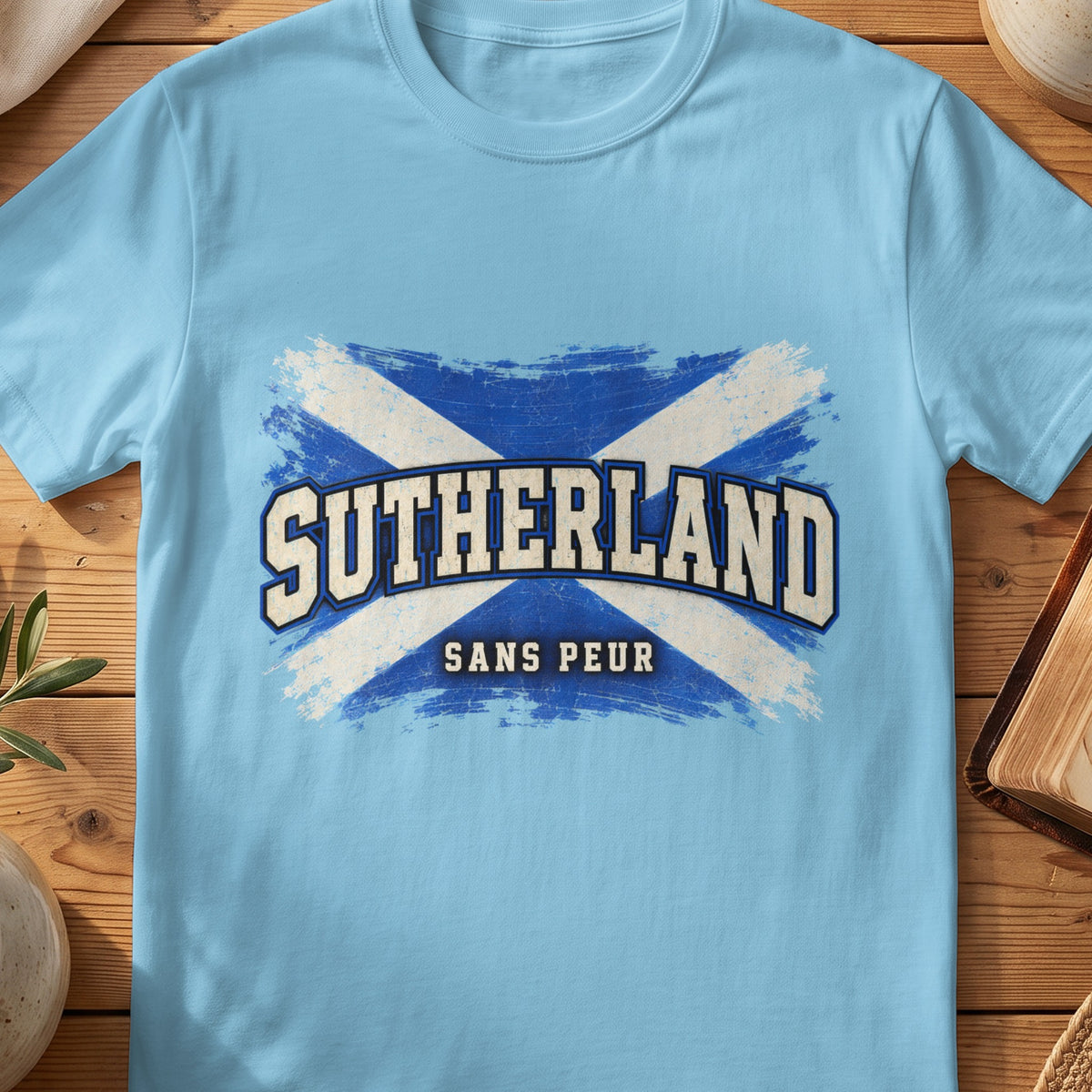 Sutherland Scottish Saltire T-shirt in Sky, with distressed blue and cream flag and “Sans Peur” lettering.