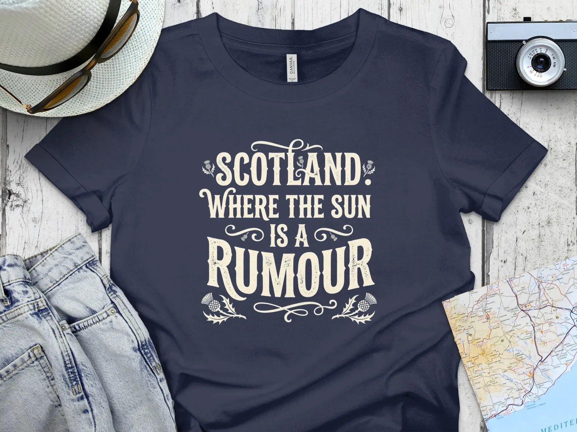 Navy t-shirt with "Scotland, Where the Sun is a Rumour" text and thistle designs.
