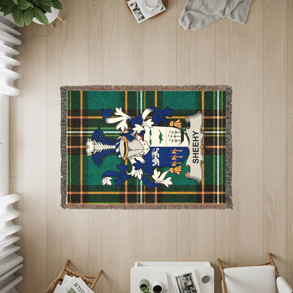 Green tartan throw blanket with SHEEHY coat of arms at its center.
