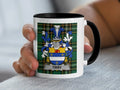 Mug with Tirry coat of arms on tartan background held by a hand.