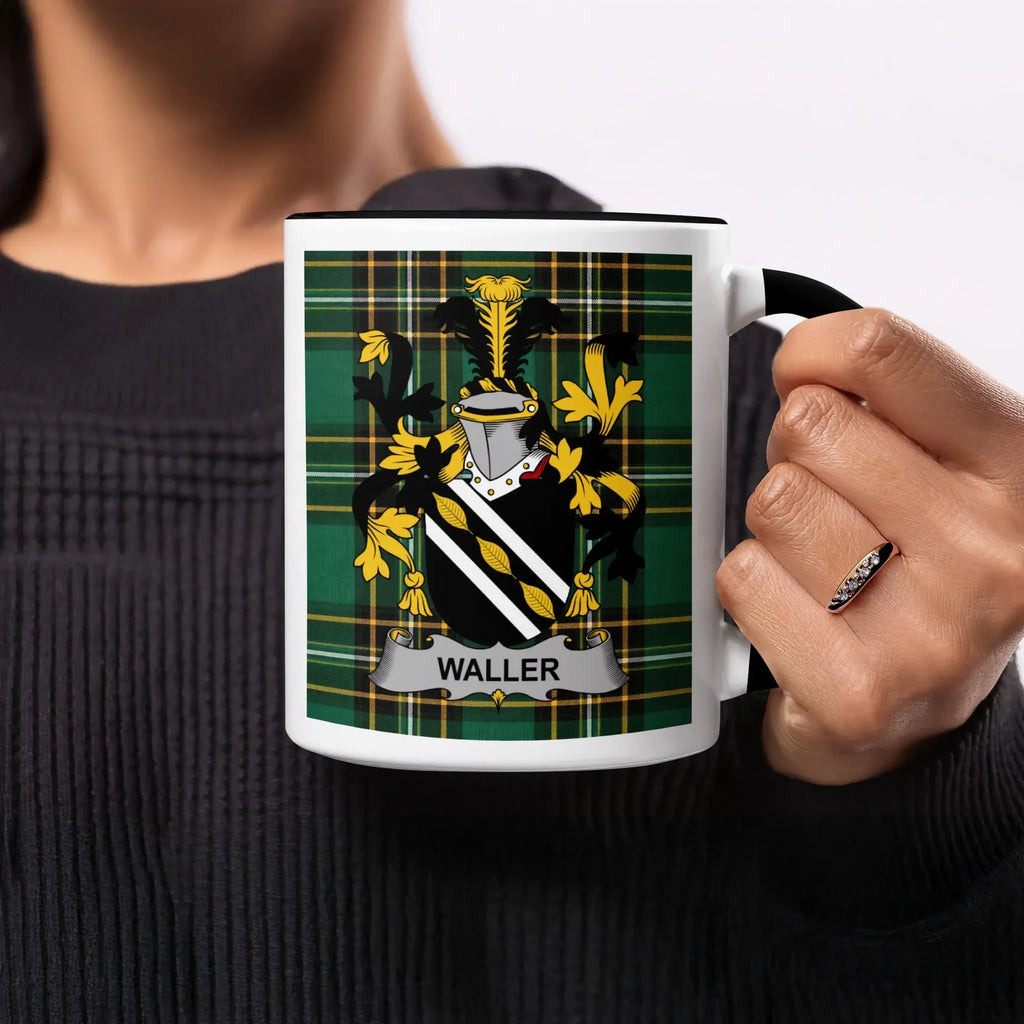 Mug with Waller family crest on green plaid background, held by person.