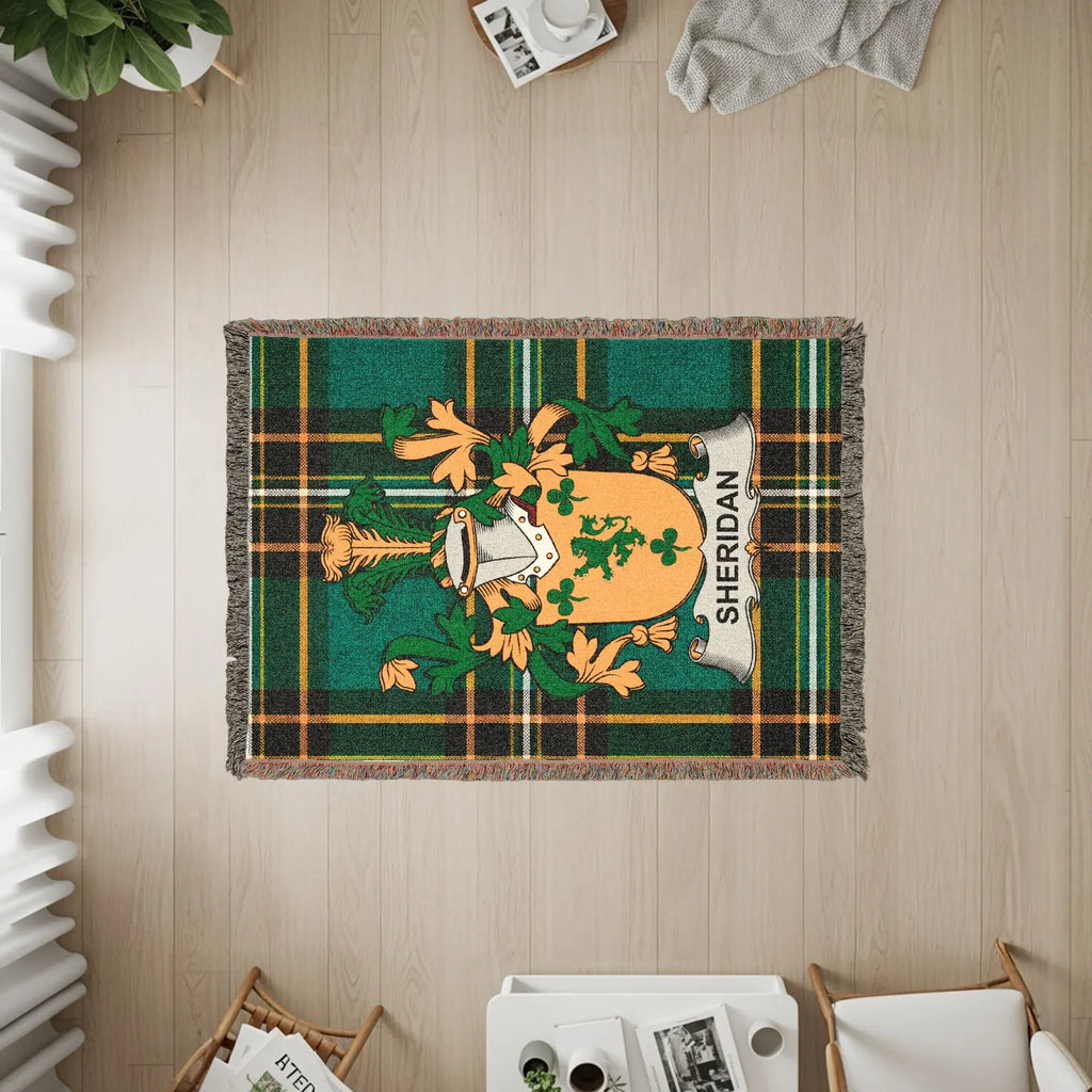 Sheridan clan crest on a green and black tartan throw blanket.