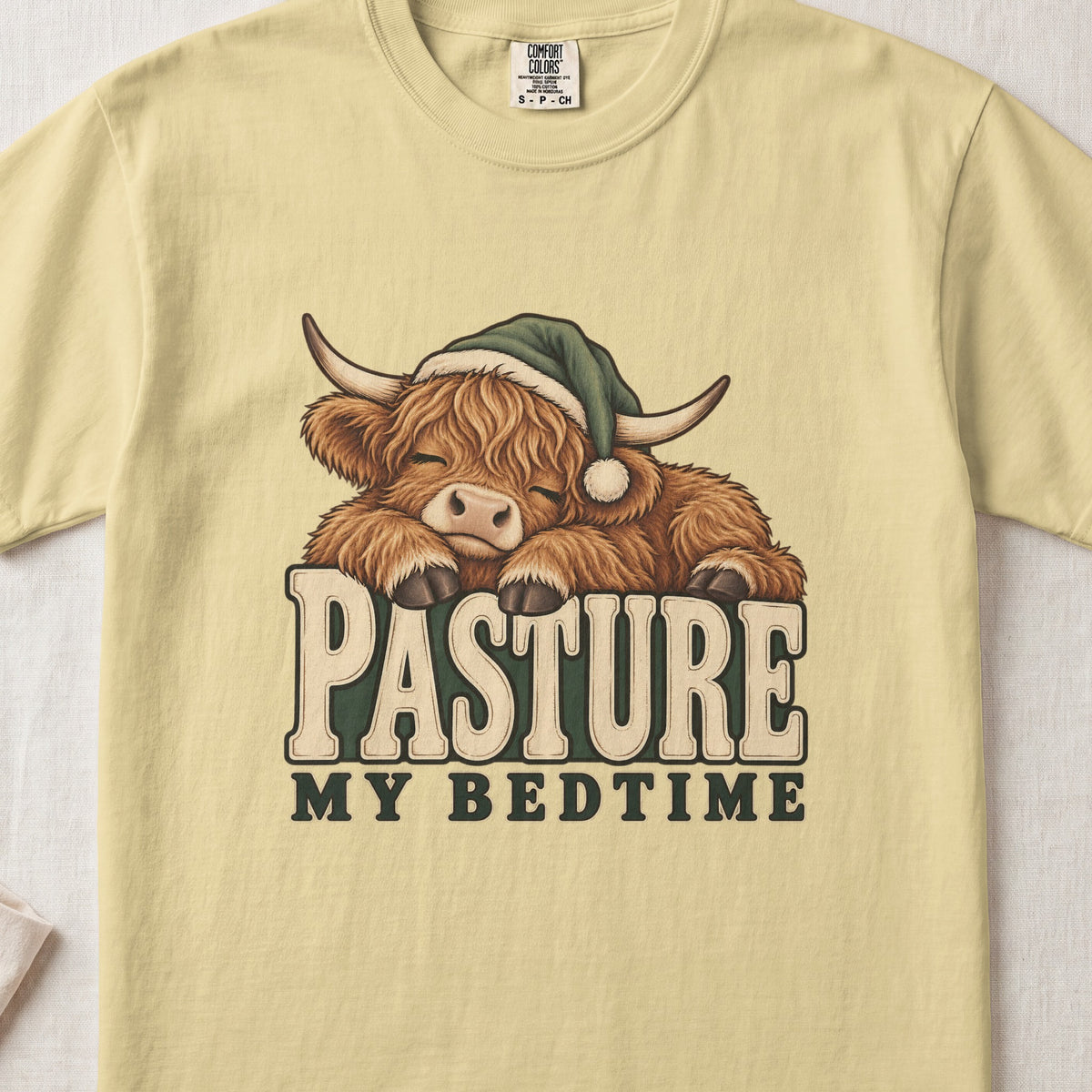 Pasture My Bedtime Highland cow design on a Butter Comfort Colors 1717 T-shirt, flat lay