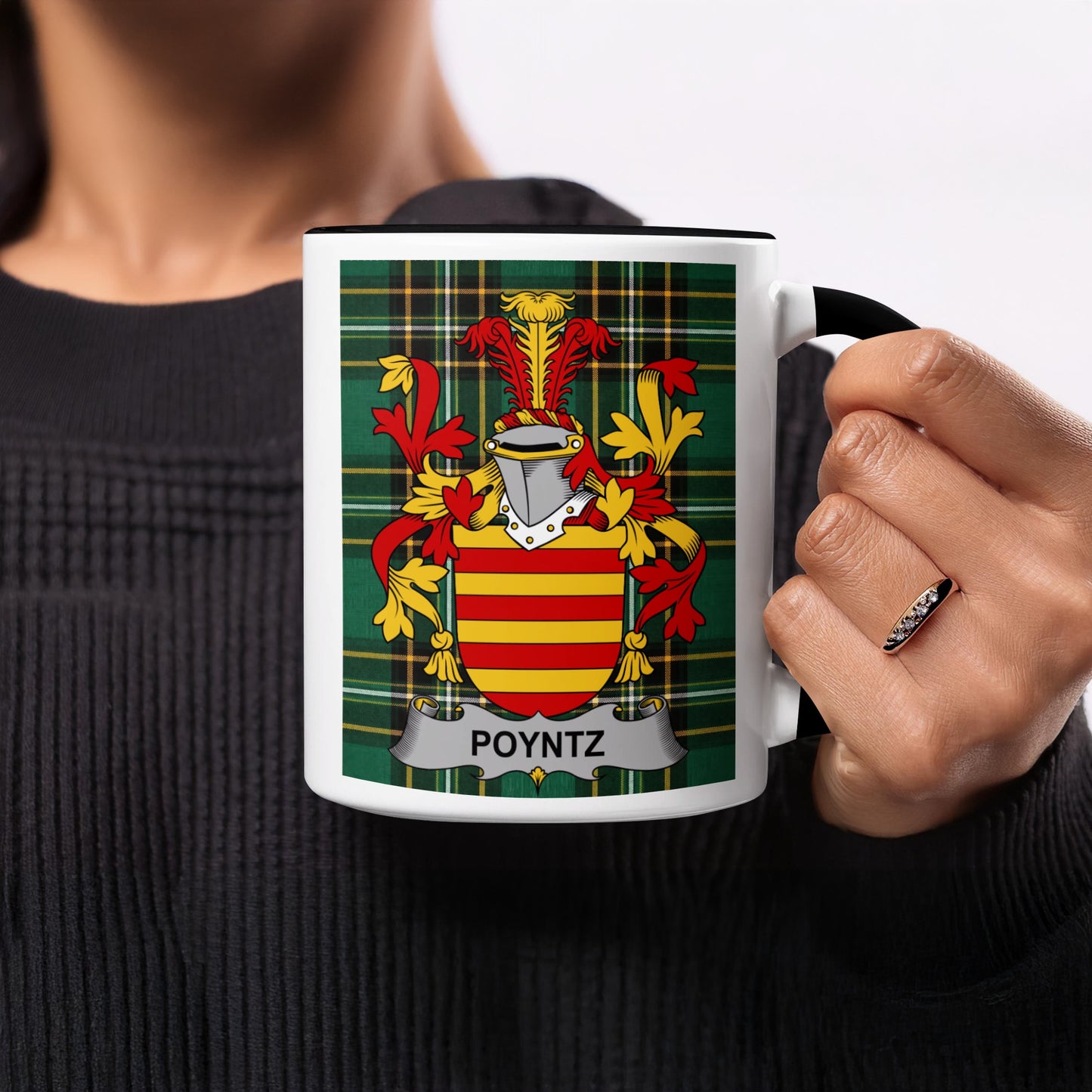 Mug with Poyntz crest on a tartan background held by a person.
