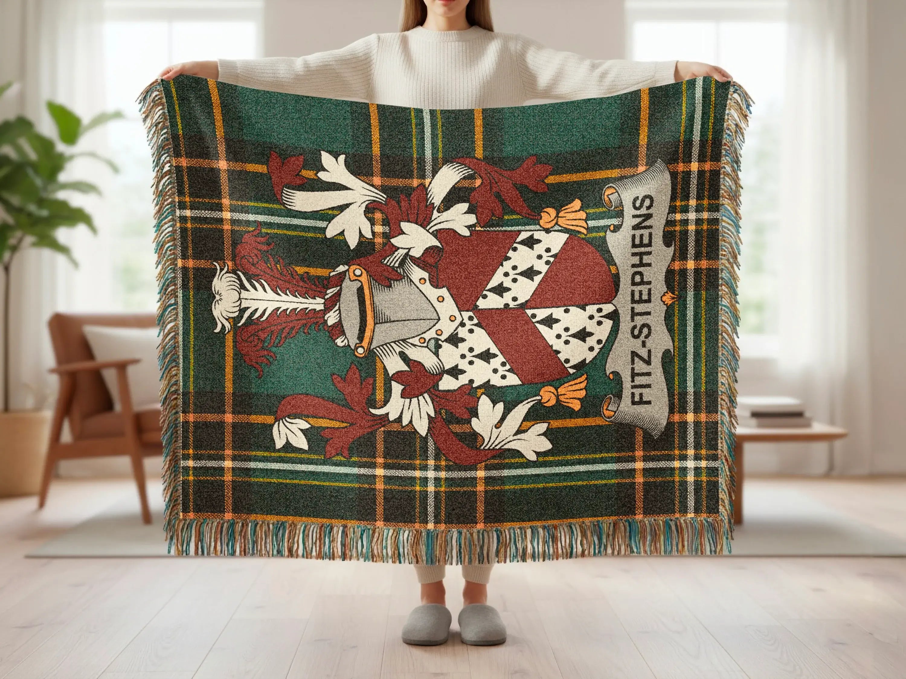 Tartan throw blanket with Fitz-Stephens crest, held by a person.