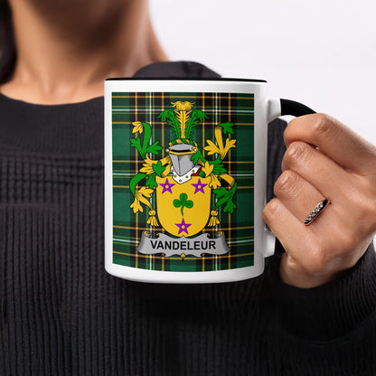 Vandeleur family crest on green plaid mug held by a person.