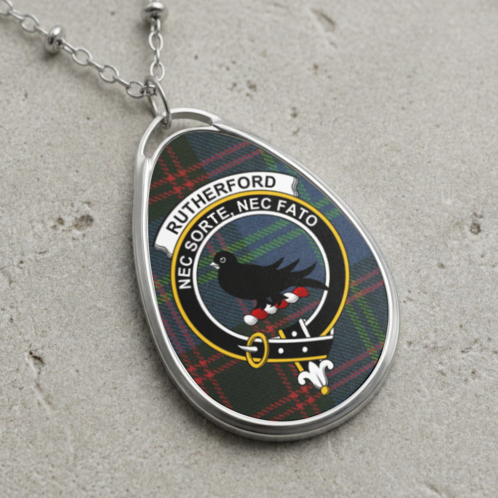 Oval pendant necklace with Rutherford clan crest and tartan background.