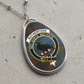 Oval pendant necklace with Rutherford clan crest and tartan background.