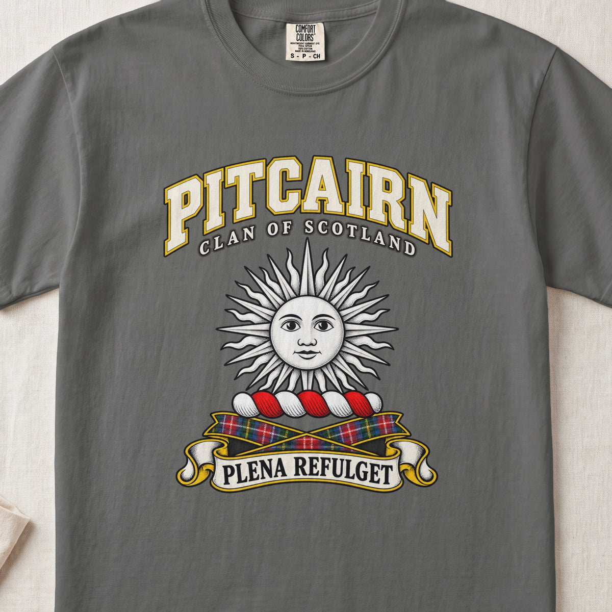 Pitcairn Scottish clan T-shirt in Pepper, front view with a silver sun with a face and motto design.
