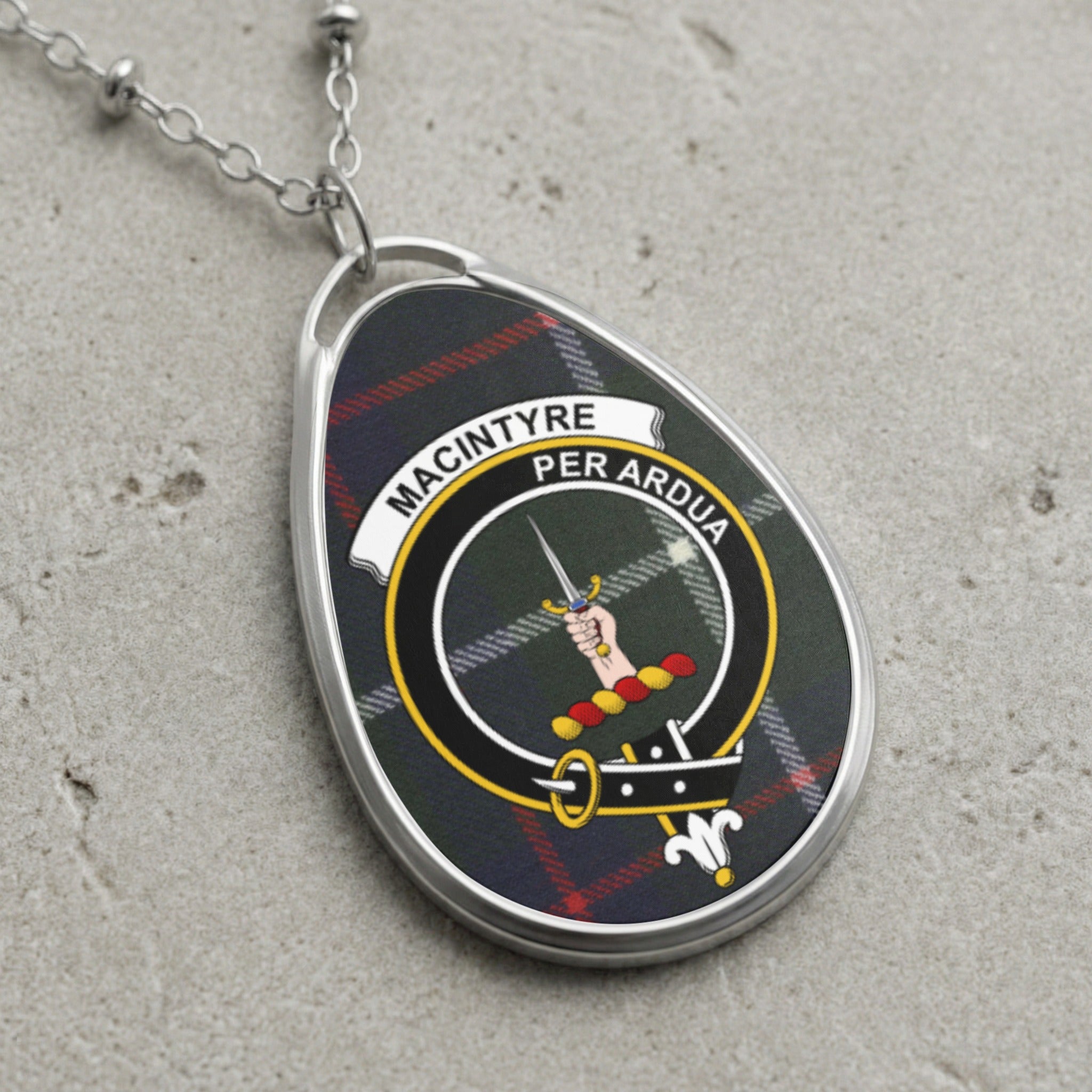 MacIntyre clan badge pendant with text "MACINTYRE PER ARDUA" on tartan.
