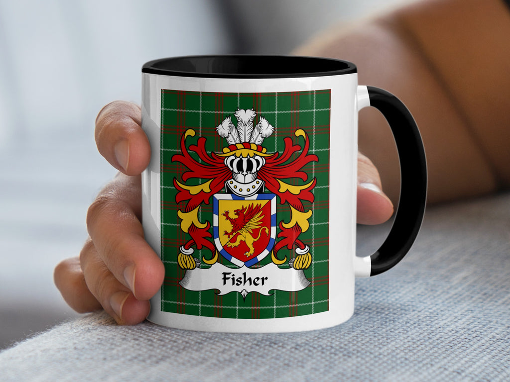 Mug with Fisher coat of arms on green plaid background, held by a hand.
