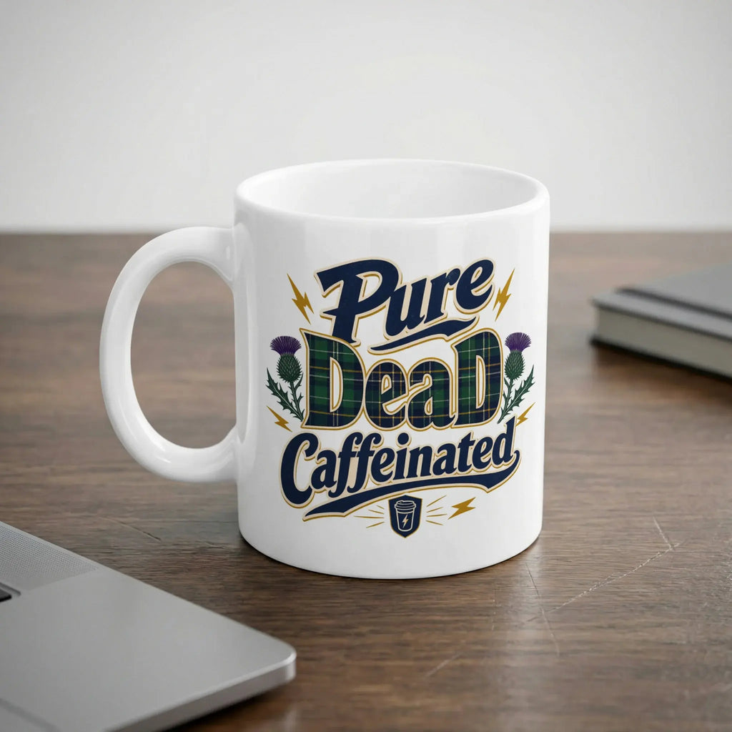 White mug with "Pure Dead Caffeinated" text and Scottish tartan thistle design.