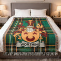 Worthing crest on a green tartan plaid blanket draped on a bed.