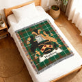 Green plaid blanket with Hopkins family crest on a bed.