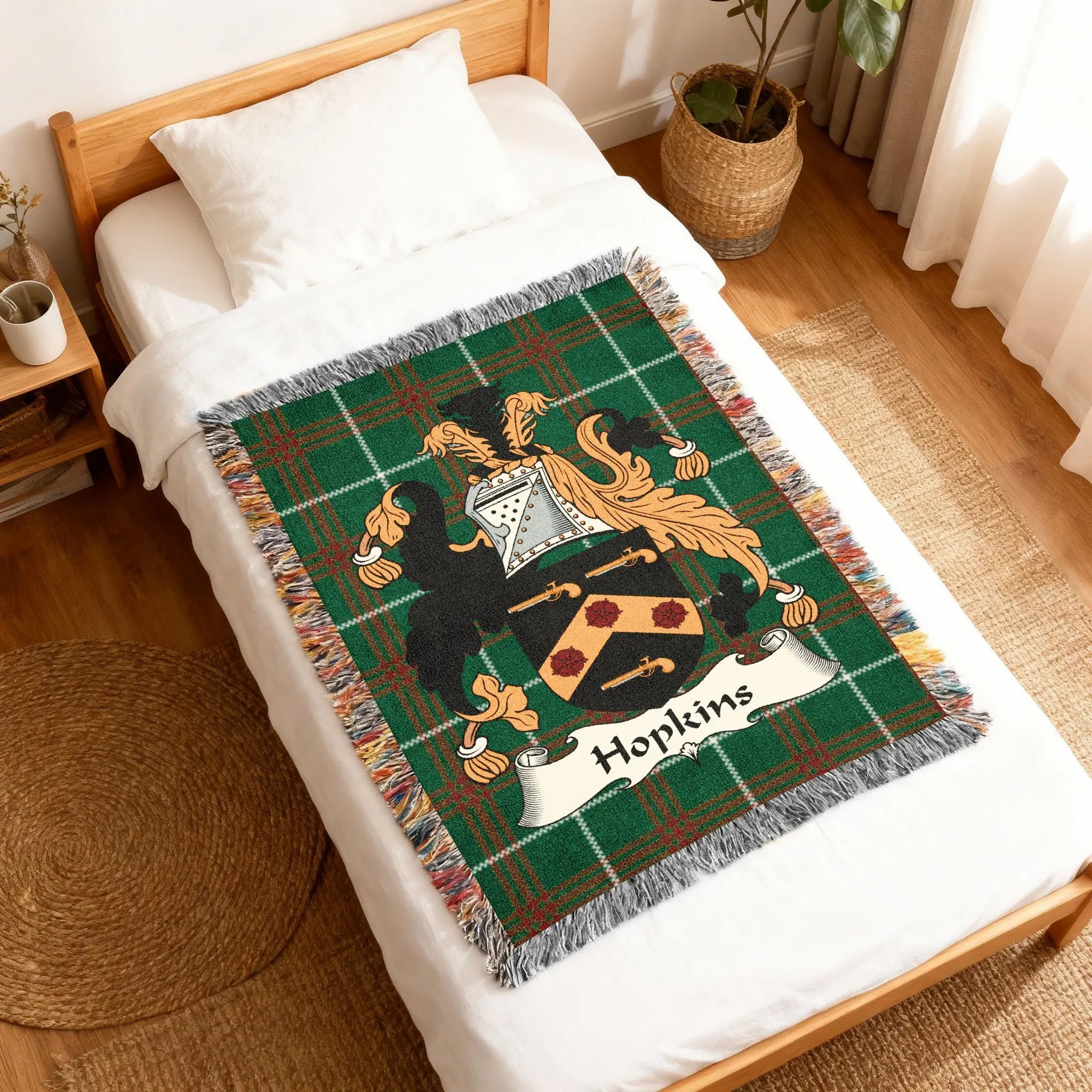 Green plaid blanket with Hopkins family crest on a bed.