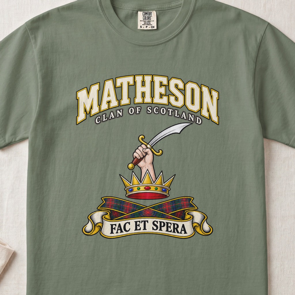 Matheson Scottish clan T-shirt in Moss, front view with a hand holding a curved sword above a gold crown and motto banner.