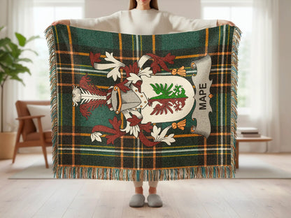 Tartan blanket with crest and "MAPE" text, held by person.