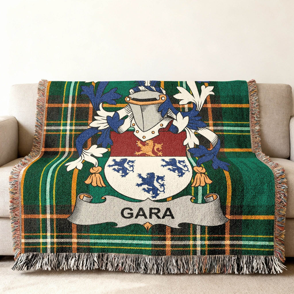 Gara family crest on a green plaid woven throw blanket on a sofa.